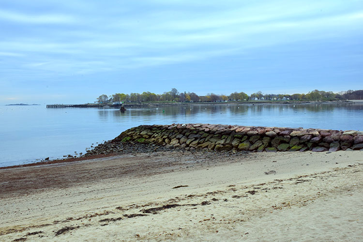 Photograph of the break water at the beach at Independence Park. The stones are banded with the life between air and water.